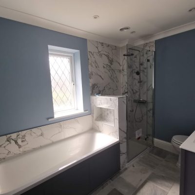 family bathroom remodel in banstead with light blue walls and marble tiles